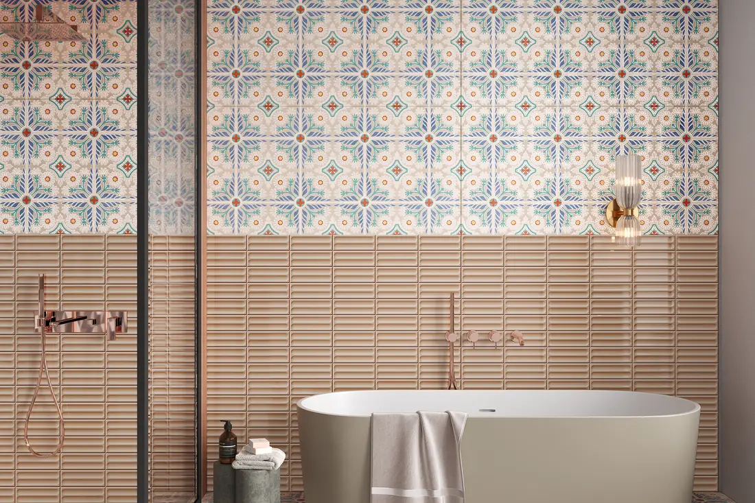 Bathroom wall with blue and terracotta patterned tiles above a band of ribbed blush wall tiles