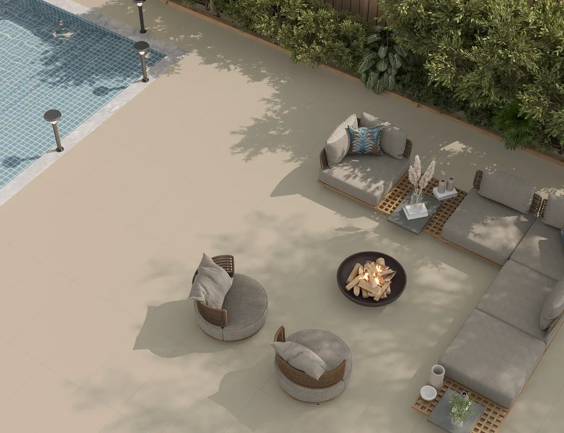 Gala Matt Camel tiles covering a poolside terrace with outdoor sofas and a fire pit, seen from above