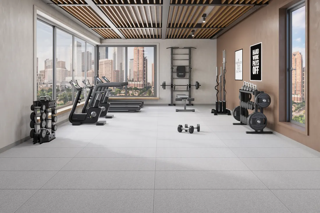 Granite Matt River tiles across the floor of a city-view gym with treadmills and weight racks